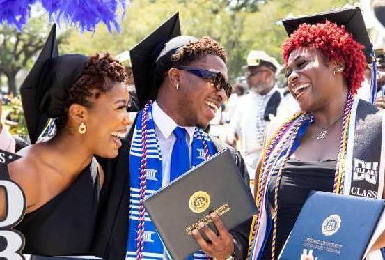 three Dillard University students with diploma's at commencement ceremony