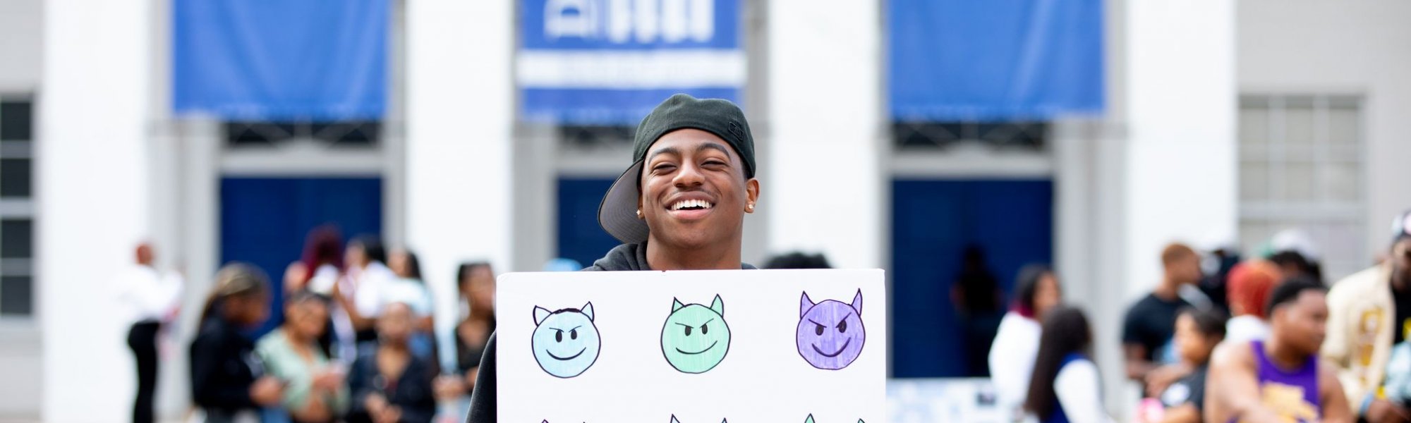 DU Student at orientation holding sign