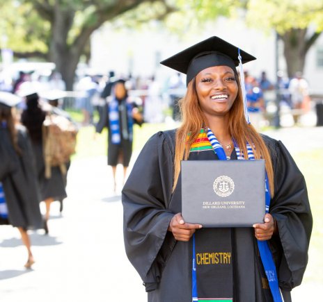 Dillard University student at graduation holding diploma