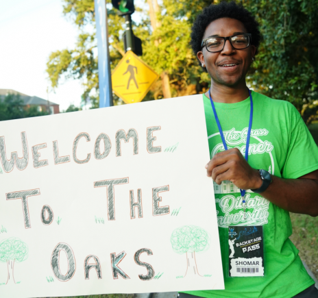 homar Michael '26 Holds Sign Welcoming the Incoming Students